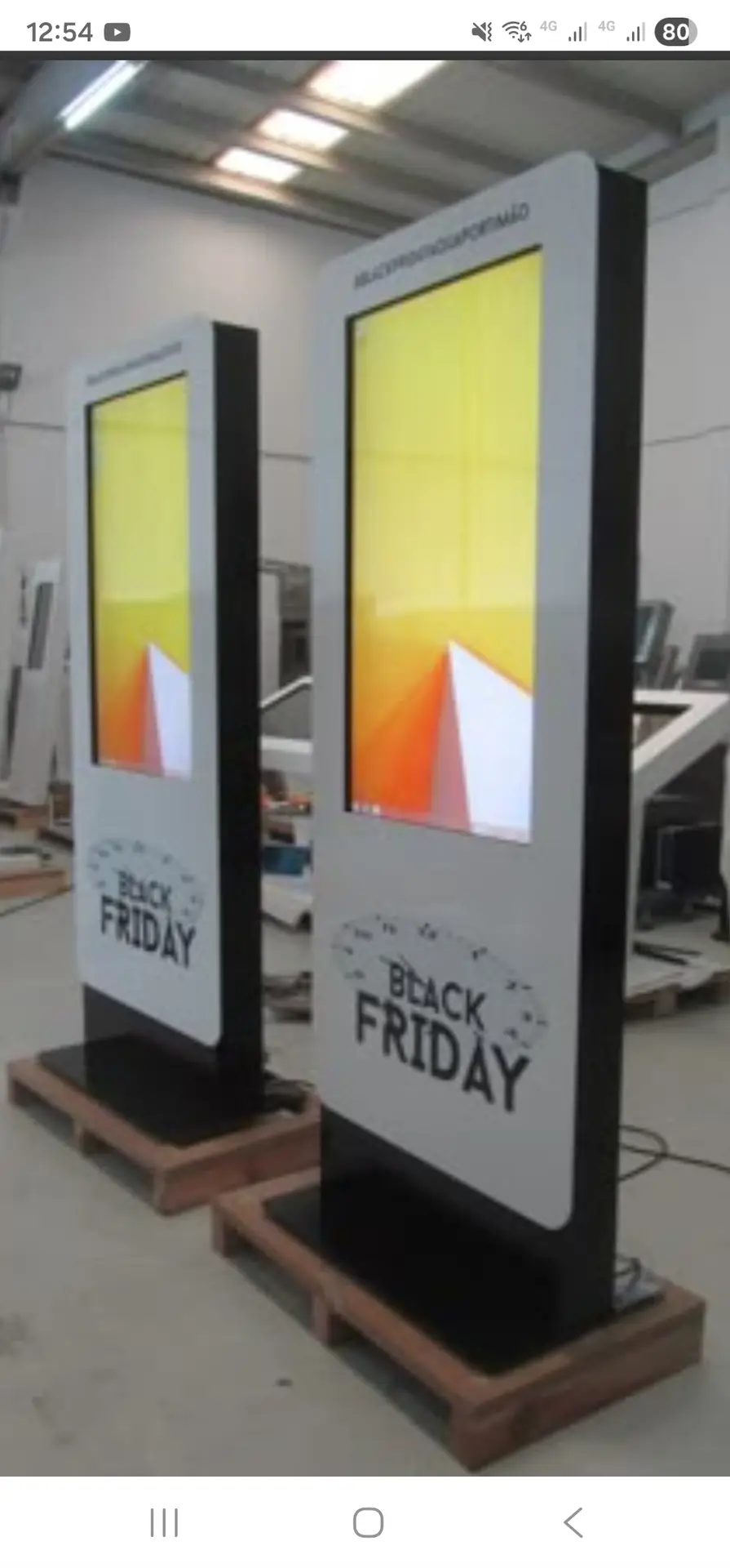 About Totem digital da QS Mídia exibindo anúncios e promoções em comércio local, voltado para lojistas e clientes.